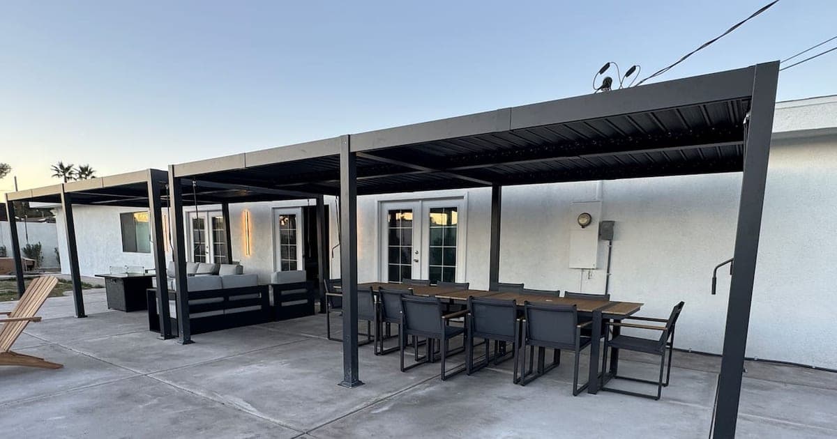 Covered patio with lounge seating and an outdoor dining table at a vegasbnb Las Vegas vacation home