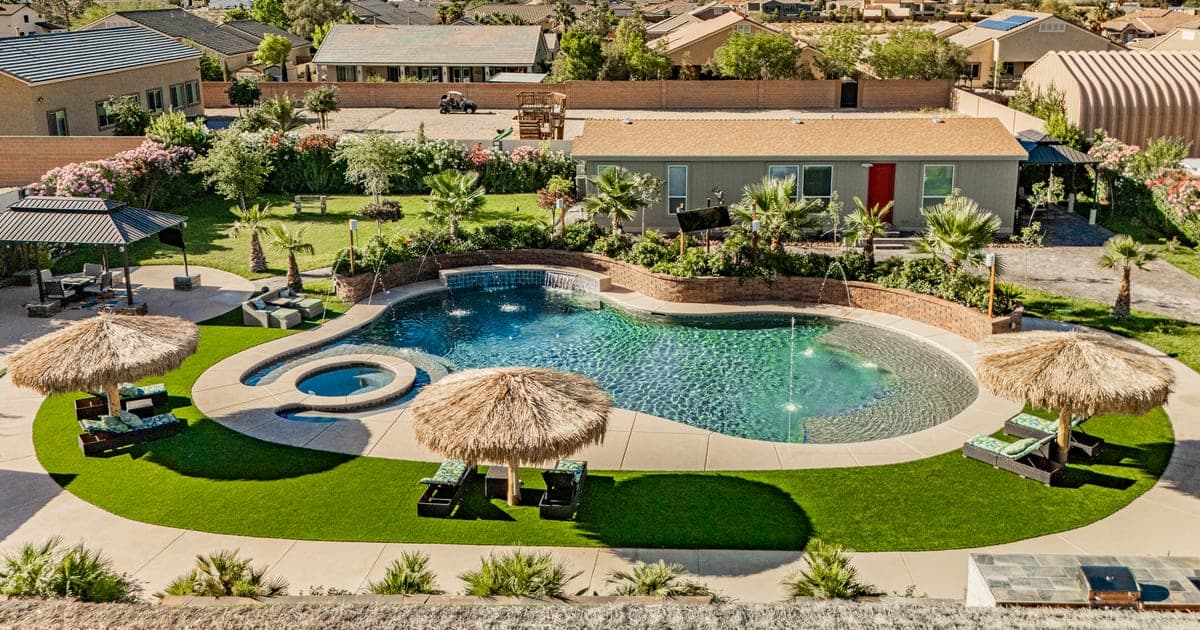 Aerial view of a vegasbnb Las Vegas vacation home pool with the city skyline and mountains in the distance